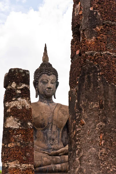 Estatua de Buddha detrás de pilares — Foto de Stock