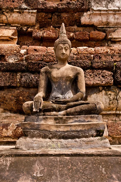 Ruína estátua de Buda na frente da parede vertical — Fotografia de Stock