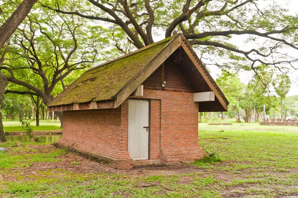 Cihlová chata v parku zblízka nakloněné — Stock fotografie