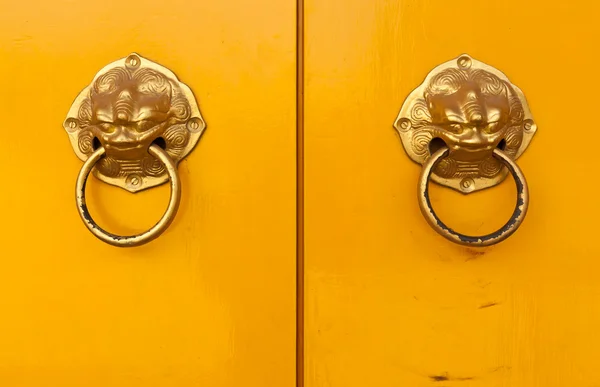 Chinese door handles on yellow doors — Stock Photo, Image