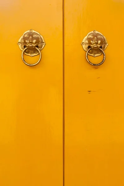 Κινεζική πόμολα στις κάθετες κίτρινο πόρτες — Φωτογραφία Αρχείου