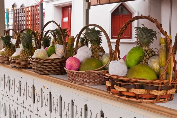 Frutas en canasta sobre estantes inclinados a la izquierda Imagen De Stock