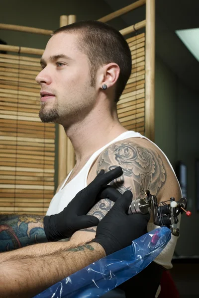 Man getting tattooed on arm
