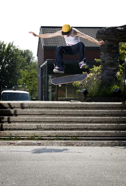 Skateboarder doing a frontside flip down stairs