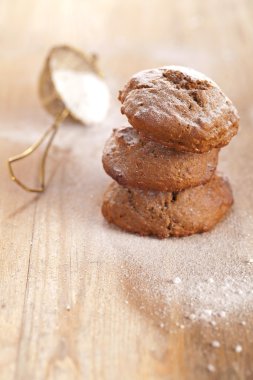 Soft ginger cookies three stacked and dusted on wooden table clipart