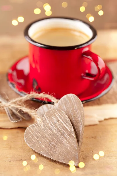 Espresso-Kaffee, roter Emaille-Becher, zwei Holzherzen und festliche — Stockfoto