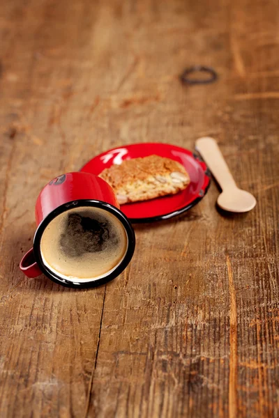 Overturned espresso coffee in red enamel mug with saucer, woode — Stock Photo, Image