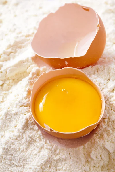 Huevo roto con cáscaras sobre harina —  Fotos de Stock