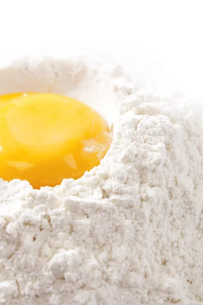Ψήνουμε! κρόκο αυγού σε αλεύρι, λευκό φόντο — Φωτογραφία Αρχείου