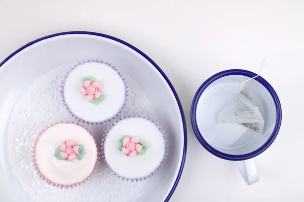 Festve cupcakes with sugar flowers with blue trimmed enamelware — Stock Photo, Image