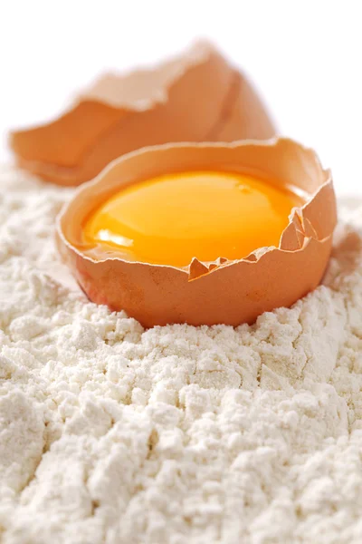 Uovo rotto con gusci su farina, sfondo bianco — Foto Stock