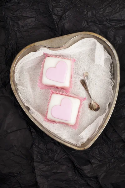 Roze cupcakes in hart gevormde paper tin, zwarte achtergrond — Stockfoto