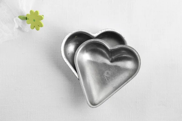 Dvě srdce dort plechovky, romance kuchyňské nádobí s peg květi — Stock fotografie