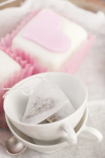 Pequenas xícaras de chá e cupcakes cor de rosa coração , — Fotografia de Stock