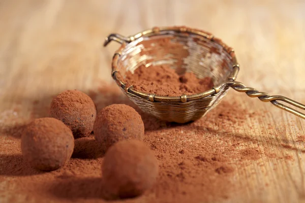 Chocolade truffels cacao poeder bestrooid en zeef, ondiep dof — Stockfoto