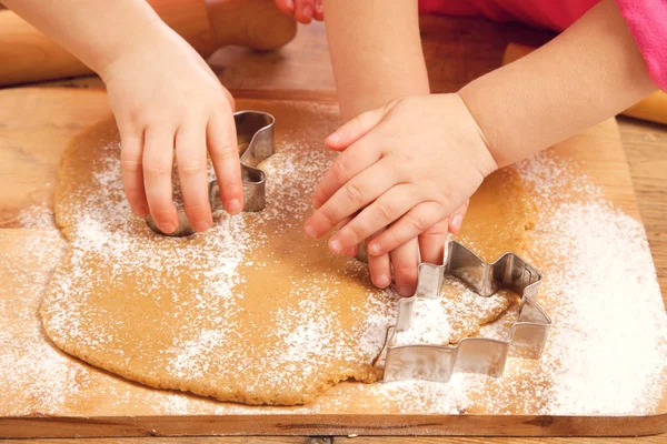 Little girls cutting christmas gingerbread cookies, hands only — Stock Photo, Image