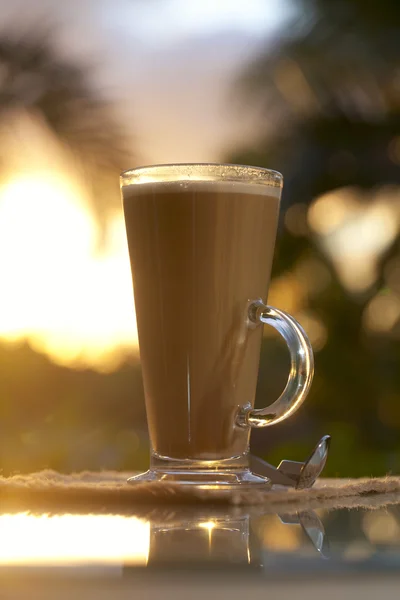 Kawa latte w niebo, Dłoń drzewo i zachód tło, ciepłe światło — Zdjęcie stockowe