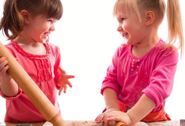 Twee kleine meisjes met rolling pinnen koekjes bakken — Stockfoto