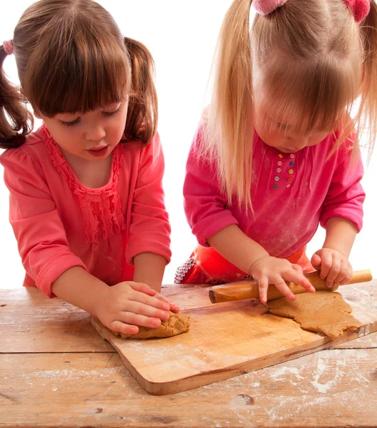 Yoğurma ve zencefilli kurabiye hamuru haddeleme iki meşgul küçük kız — Stok fotoğraf