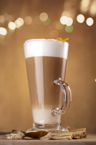 Kaffe latte med ljus på bakgrunden i ett högt glas — Stockfoto