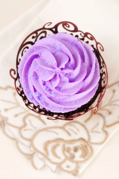 Cupcake con top di lavanda in involucro festivo su beige — Foto Stock