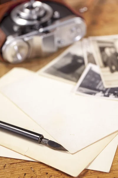 Старинная чернильная ручка, старые фотографии и камера — стоковое фото