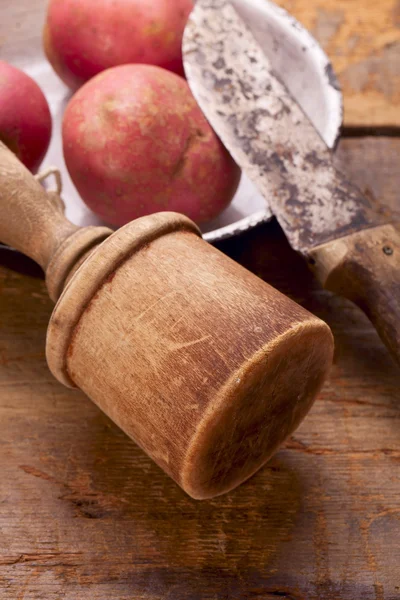 Stock image Retro potato masher and knife on old wooden table with potato