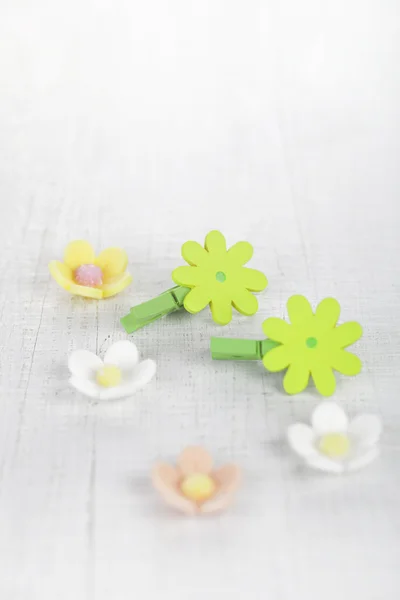 Decorative flower pegs with sugar flowers on white old table — Stock Photo, Image