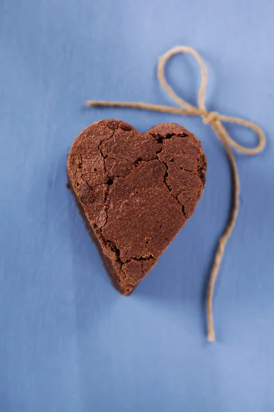 Επιδόρπιο brownie σοκολάτας σε σχήμα καρδιάς για μπλε ξύλινο τραπέζι — Φωτογραφία Αρχείου