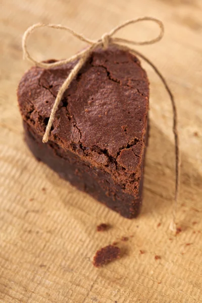 Corazón brownie chocolate con arco, fondo de madera áspera —  Fotos de Stock