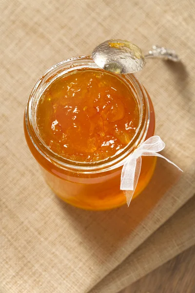 Pomarańczowy cienkie cięcia Marmolada lub dżem w słoiku z łyżeczką — Zdjęcie stockowe