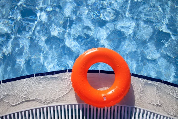 Anel laranja flutuante na borda da piscina com ondas refletindo i — Fotografia de Stock