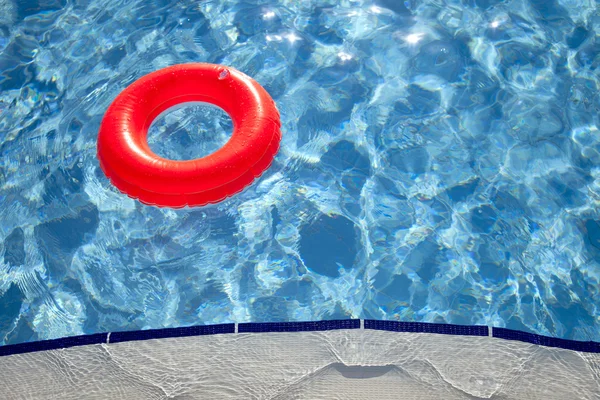 Schwimmender orangefarbener Ring am Rand des Swimmingpools mit Wellen, die i reflektieren — Stockfoto