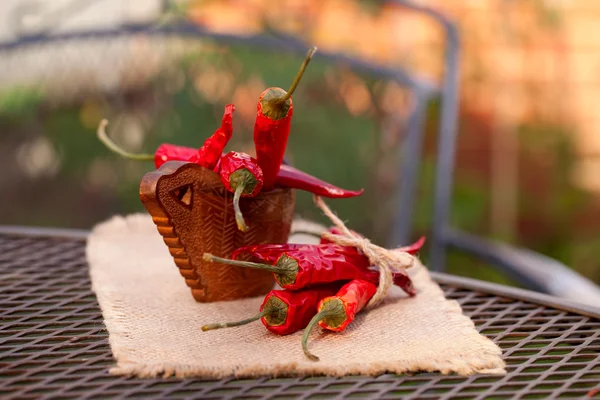 Rote Chilischoten pfeffern in einer gebogenen Holzschale in einem Garten — Stockfoto