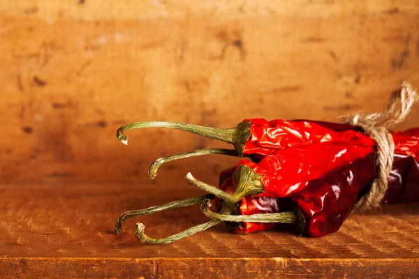 Heiße rote Chilischoten Papierbündel in Holzkiste — Stockfoto