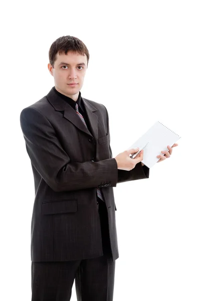 Молодой человек в классическом костюме, показывает ручку в блокноте — стоковое фото