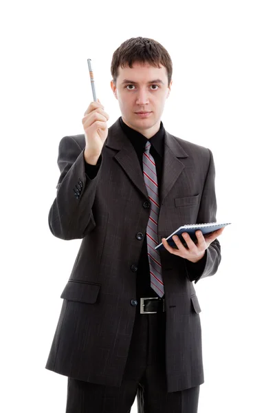 Νέος άνθρωπος σε ένα κοστούμι με ένα σημειωματάριο και στυλό στο χέρι — Φωτογραφία Αρχείου