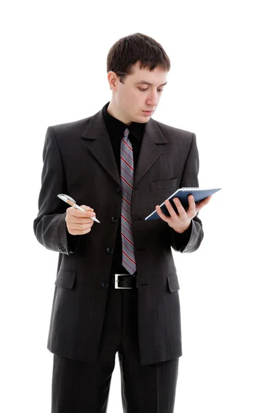 Młody człowiek w garniturze, wygląda w notatniku. — Zdjęcie stockowe