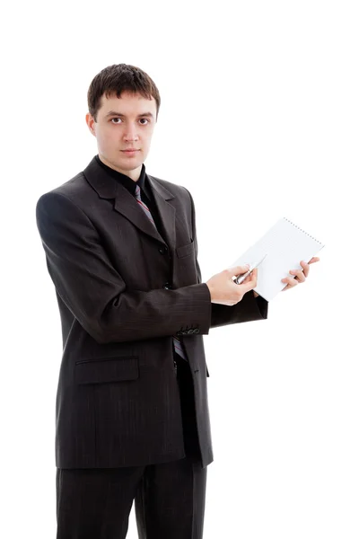 En ung man i kostym visar en penna i en anteckningsbok. — Stockfoto
