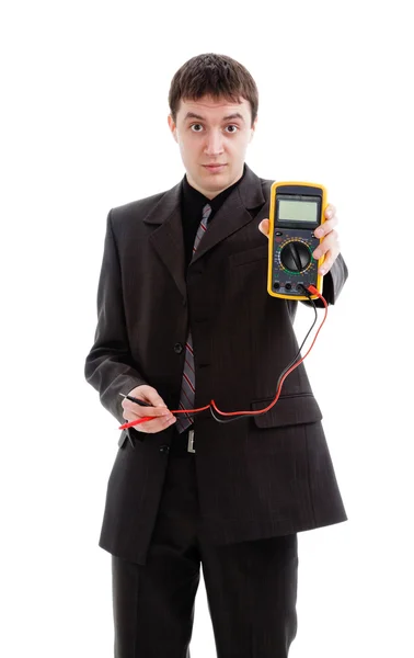 Mladý muž v obleku ukazuje multimetr. — Stock fotografie