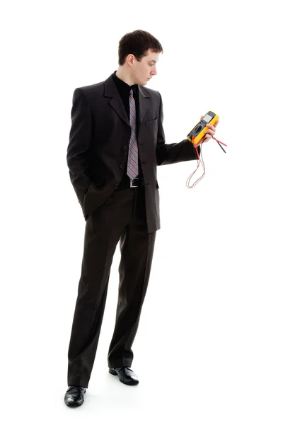 Молодой человек в костюме, смотрит на показания мультиметра . — стоковое фото