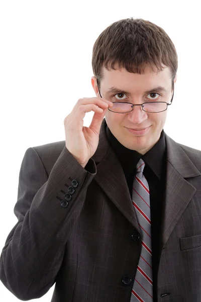 Młody człowiek w garnitur i krawat, patrząc na jego okulary. — Zdjęcie stockowe