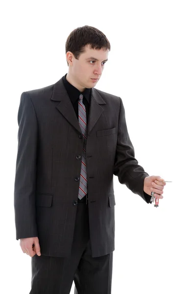 Νεαρός άνδρας σε ένα κοστούμι, με τα κλειδιά που απομονώνονται σε ένα λευκό αμουδερές — Φωτογραφία Αρχείου