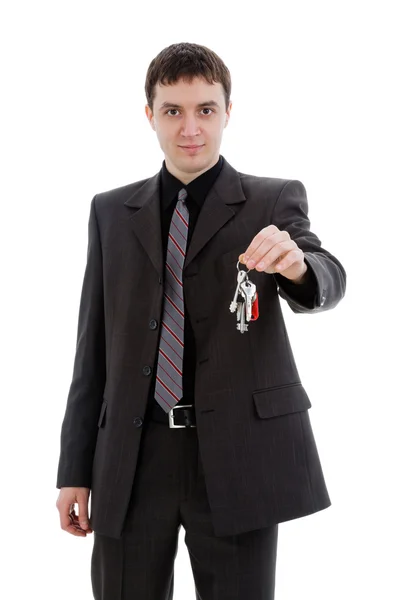 Young man in a suit, offering the keys, — Stock Photo, Image