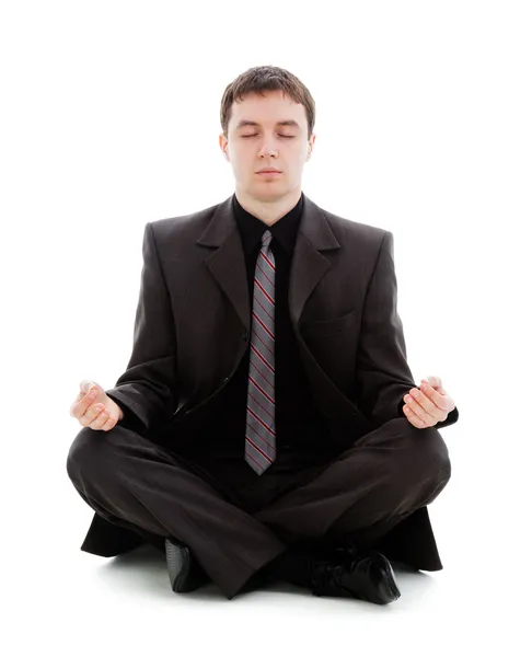 若い男はスーツとネクタイ、床に座って瞑想します。. ロイヤリティフリーのストック画像