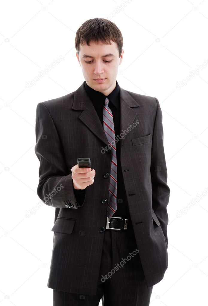 A young man in a suit, dials a number in the phone.