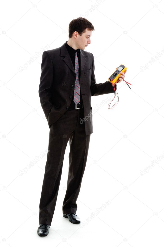 A young man in a suit, looks at the testimony of a multimeter.