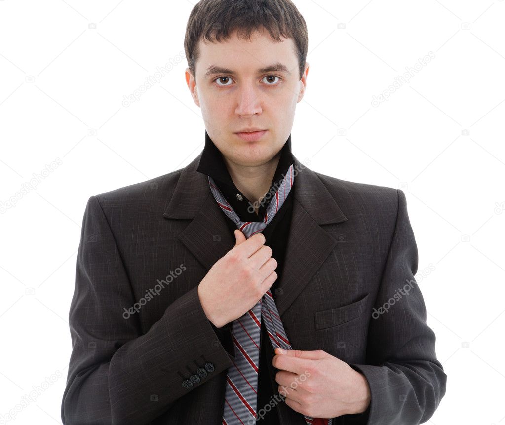 Young man in a suit, tie a tie.