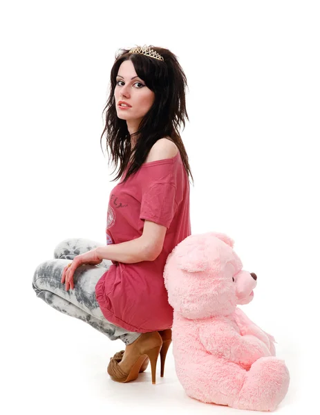 年轻性感的女孩坐着一只玩具熊被隔绝在白色背景上. — 图库照片