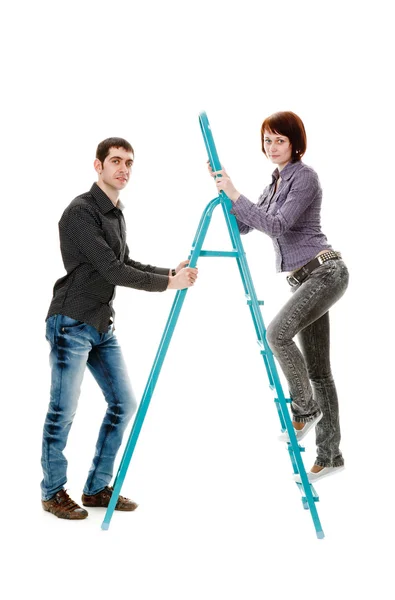 Guy holding the ladder on which to climb up the girl. — Stock Photo, Image